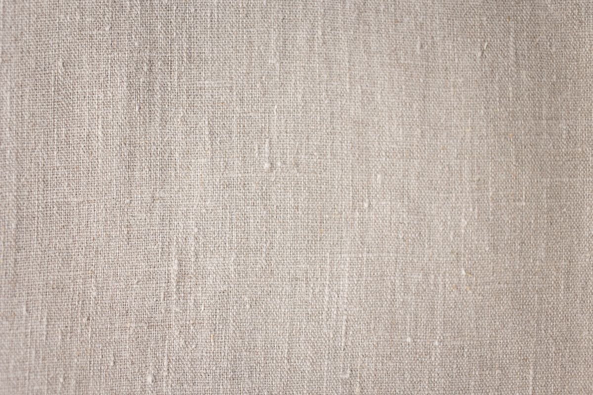 Close-up of natural linen showing its open weave and slubs